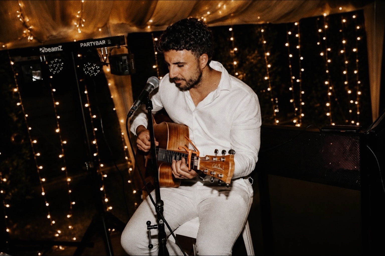 Jase Invo performing live acoustic guitar at a wedding reception
